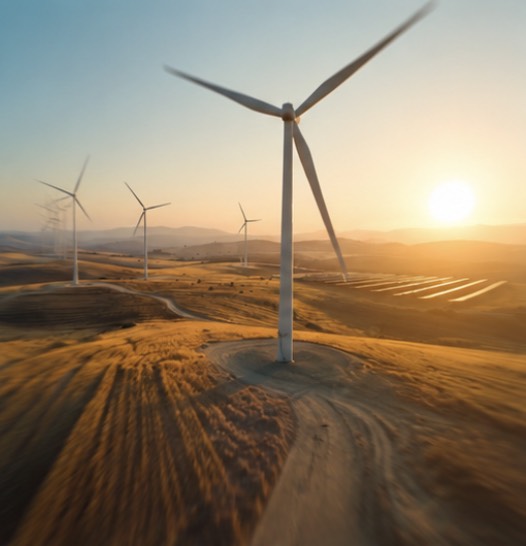 Éoliennes sur des collines dorées au coucher du soleil